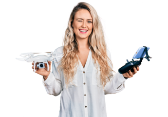 Young blonde woman holding television remote control winking looking at the camera with sexy expression, cheerful and happy face.