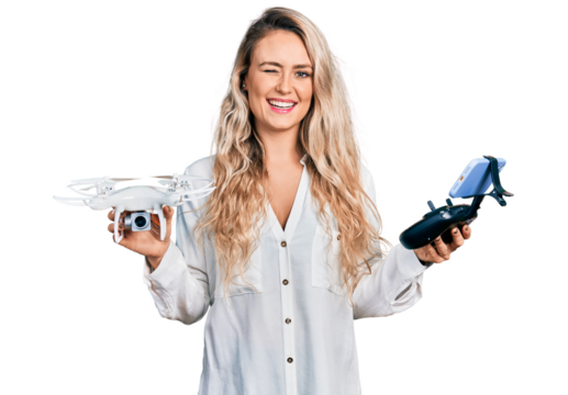 Young blonde woman holding television remote control winking looking at the camera with sexy expression, cheerful and happy face.