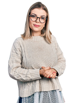 Young blonde woman wearing glasses with hands together and crossed fingers smiling relaxed and cheerful. success and optimistic