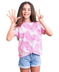 Cute hispanic child girl wearing casual clothes showing and pointing up with fingers number seven while smiling confident and happy.