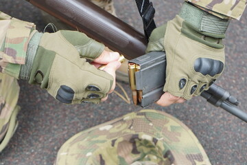 Poltava-Kharkiv region, Ukraine - August 2022: Ukrainian military man receives cartridges for a machine gun. A soldier of a volunteer formation of a territorial community inserts cartridges