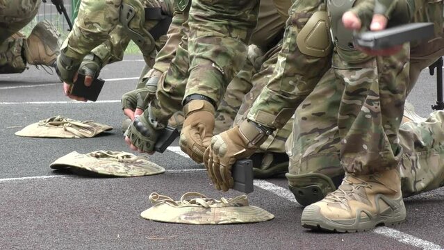 Poltava-Kharkiv region, Ukraine - August 2022: Ukrainian military man receives cartridges for a machine gun. A soldier of a volunteer formation of a territorial community inserts cartridges