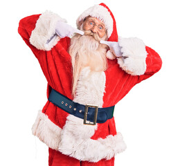 Old senior man with grey hair and long beard wearing traditional santa claus costume smiling cheerful showing and pointing with fingers teeth and mouth. dental health concept.