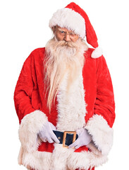 Old senior man with grey hair and long beard wearing traditional santa claus costume skeptic and nervous, frowning upset because of problem. negative person.