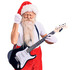 Old senior man with grey hair and long beard wearing santa claus costume playing electric guitar...