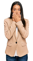 Beautiful hispanic woman wearing business jacket shocked covering mouth with hands for mistake. secret concept.