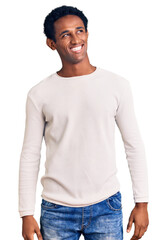 Fototapeta premium African handsome man wearing casual winter sweater looking away to side with smile on face, natural expression. laughing confident.