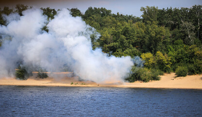 Smoke and fire on the river bank
