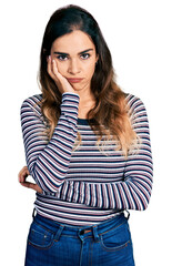 Beautiful hispanic woman wearing casual striped shirt thinking looking tired and bored with depression problems with crossed arms.