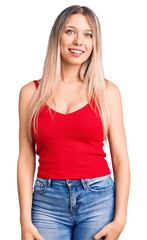 Young beautiful blonde woman wearing casual clothes looking positive and happy standing and smiling with a confident smile showing teeth