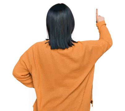 Young hispanic woman wearing casual clothes posing backwards pointing ahead with finger hand