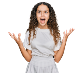 Teenager hispanic girl wearing casual white t shirt crazy and mad shouting and yelling with aggressive expression and arms raised. frustration concept.