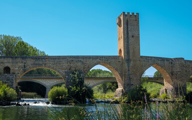 Fototapeta na wymiar Antiguo puente medieval de origen romano con torre fortificada del siglo XV sobre el río Ebro a su paso por la villa de Frías, España