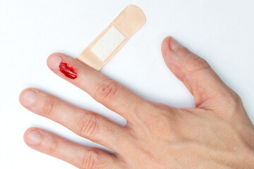 The man cut his finger and is bleeding. Accident. Top view. Providing first aid, sticking a medical...