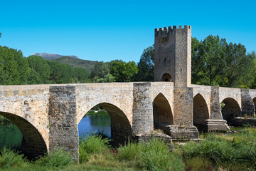 Fototapeta na wymiar Vista del puente medieval de origen romano con torre fortificada del siglo XV sobre el río Ebro a su paso por la villa de Frías, España