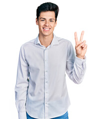 Fototapeta premium Young hispanic business man wearing business clothes showing and pointing up with fingers number two while smiling confident and happy.