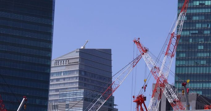 Moving cranes at the under construction daytime long shot