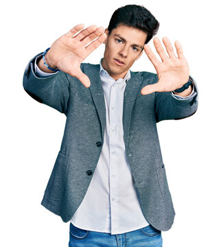 Young hispanic man wearing business clothes doing frame using hands palms and fingers, camera perspective