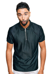Obraz premium Young man with beard wearing sportswear afraid and shocked with surprise expression, fear and excited face.