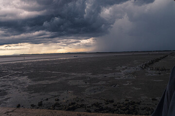 Storm clouds with the rain fall in the sea at sunset. horizontol scenic Dark huge cloud sky black stormy cloud