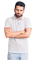 Obraz premium Young handsome man with beard wearing casual polo skeptic and nervous, disapproving expression on face with crossed arms. negative person.