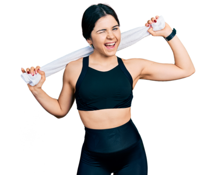 Young brunette woman with blue eyes wearing sportswear and towel winking looking at the camera with sexy expression, cheerful and happy face. - Powered by Adobe
