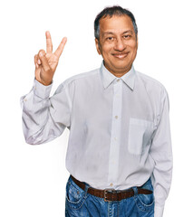 Middle age indian man wearing casual white shirt smiling with happy face winking at the camera...