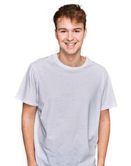 Fototapeta premium Young caucasian man wearing casual white t shirt with a happy and cool smile on face. lucky person.