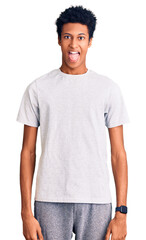 Young african american man wearing casual clothes sticking tongue out happy with funny expression. emotion concept.
