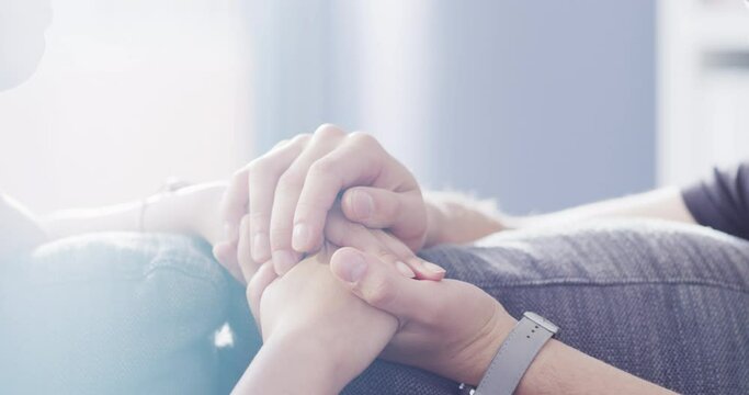 Couple, hands and hope for love and support in care for relationship, friendship and trust at home. Man and woman in hand holding for comfort on a sofa in the living room in help, empathy and loss.