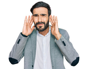 Young hispanic man wearing business clothes trying to hear both hands on ear gesture, curious for gossip. hearing problem, deaf