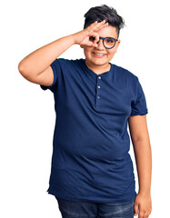 Fototapeta premium Little boy kid wearing casual clothes and glasses doing ok gesture with hand smiling, eye looking through fingers with happy face.