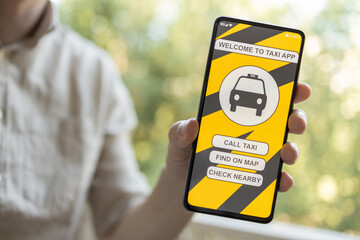 Man stand outside and holding a smartphone with taxi application on the display. Man orders a taxi from his cell phone. Close-up hands.