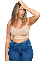 Fototapeta premium Beautiful brunette woman wearing casual clothes surprised with hand on head for mistake, remember error. forgot, bad memory concept.