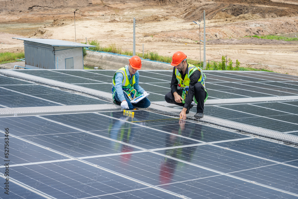 Poster Professional worker installing and checking solar panels on the roof of a factory,Innovative solution for energy solving. Use renewable resources. Green energy.