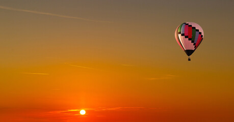 Colorful hot air balloons flying on the sunset sky background.