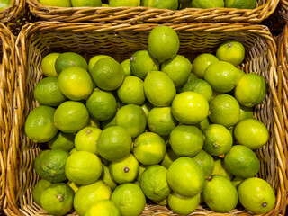 Fresh green lime fruits in basket  .Many lemons in supermarket 