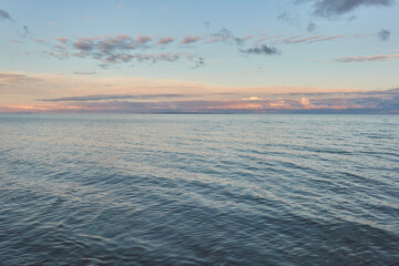 Baltic sea shore (beach) at sunset, panoramic view. Soft sunlight, midnight sun, clear sky, glowing clouds. Saaremaa island, Estonia. Atmospheric summer landscape