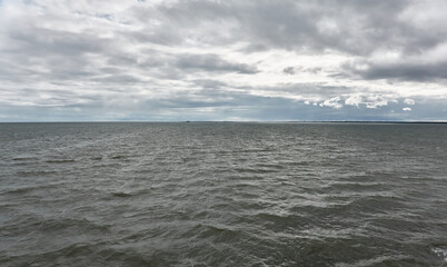 Muhu strait, Estonia, Baltic sea. Dramatic sky, storm clouds, water surface texture. Panoramic view. Nature, eco tourism, weather themes;