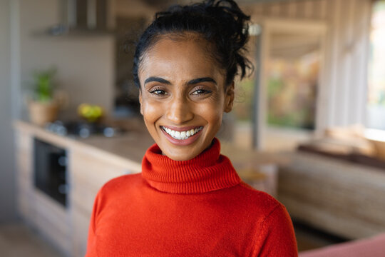 Close-up portrait of beautiful smiling biracial mid adult woman wearing turtleneck t-shirt at home