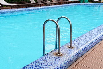 Obraz premium handrails of stairs for descent into the pool. the concept of summer holidays.