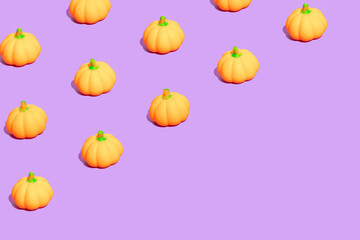 Seamless pattern made of little pumpkins on purple background. Minimal autumn, Halloween or Thanksgiving  composition.