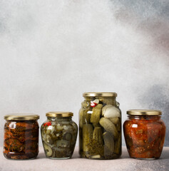 Preserving vegetables for the winter, canned vegetables in jars on a light background, pickled or fermented vegetables, copy space