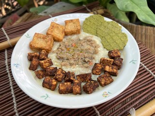 Congee with fried tempeh and stir pork and fried tofu