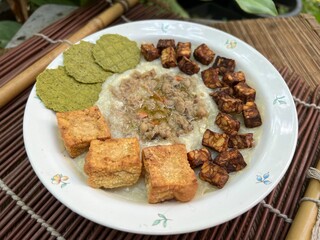 Congee with fried tempeh and stir pork and fried tofu