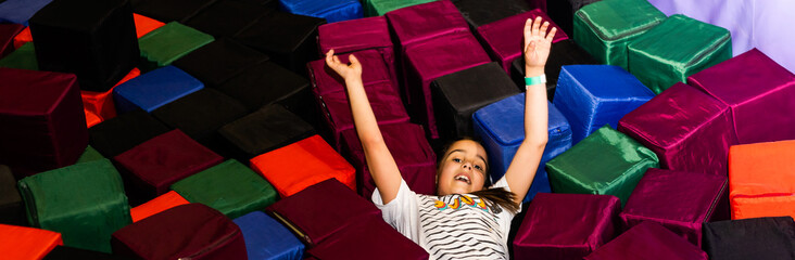 Little pretty smiling girl lying on the trampoline