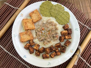 Congee with fried tempeh and stir pork and fried tofu