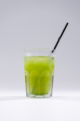 fresh cold fruit drink with green tarragon, ice, straw isolated