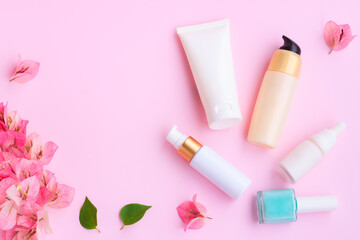 Decorative cosmetics set with pink bougainvillea flowers on pink background