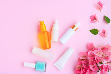 Obraz na płótnie Canvas Decorative cosmetics set with pink bougainvillea flowers on pink background